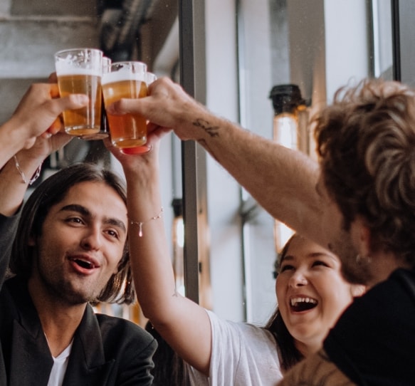 People happily clinking beer glasses together